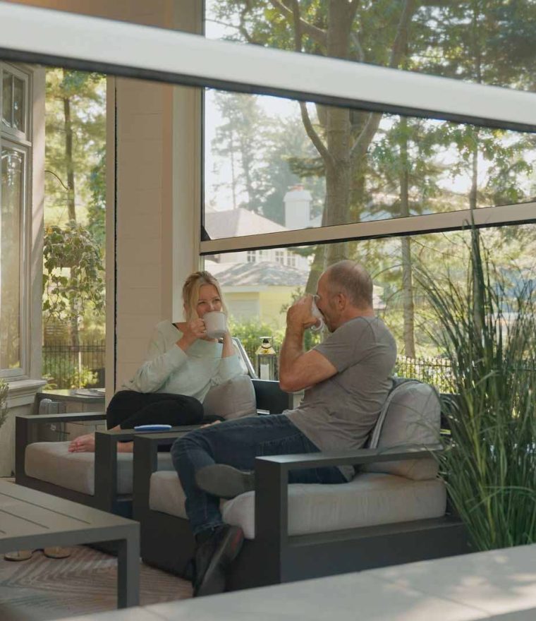 motorized outdoor mesh screens on a patio with a rock and tree garden.